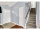 Inviting foyer with staircase, white front door, tile and wood flooring, and neutral wall color at 5369 Red River Ct, Indianapolis, IN 46221