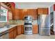 Well-lit kitchen featuring stainless steel appliances, tile backsplash, and warm wood cabinetry at 5369 Red River Ct, Indianapolis, IN 46221