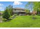 Expansive backyard with well-maintained lawn, mature landscaping, and large home featuring a screened in porch at 5419 Cayman Dr, Carmel, IN 46033
