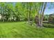 Expansive backyard featuring lush green grass, mature trees, privacy, and landscape wall at 5419 Cayman Dr, Carmel, IN 46033