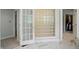 Well-lit bathroom with glass block window and open door to walk-in closet with custom shelving at 5419 Cayman Dr, Carmel, IN 46033