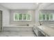Bright bathroom with soaking tub, granite counters, marble floors, and large mirror at 5419 Cayman Dr, Carmel, IN 46033