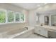 Bright bathroom with soaking tub, vanity with granite counters, and marble floors at 5419 Cayman Dr, Carmel, IN 46033