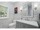 Bright bathroom featuring a marble countertop, white toilet and tiled walls at 5419 Cayman Dr, Carmel, IN 46033