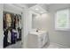 Bright bathroom featuring a white vanity, window, and walk-in closet with custom shelving at 5419 Cayman Dr, Carmel, IN 46033