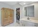 Bright bathroom featuring a white vanity, decorative cabinet, and walk-in closet with ample storage at 5419 Cayman Dr, Carmel, IN 46033