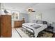 Cozy bedroom with a ceiling fan, large window, and carpet on top of hardwood flooring at 5419 Cayman Dr, Carmel, IN 46033