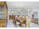 Elegant dining room with ornate wood table, upholstered chairs, chandelier, and view into the foyer at 5419 Cayman Dr, Carmel, IN 46033