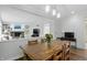 Open dining area with wood table and light fixture open to living area with fireplace and built-ins at 5419 Cayman Dr, Carmel, IN 46033