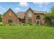 Charming two-story brick home with an arched entry, manicured lawn, and mature landscaping at 5419 Cayman Dr, Carmel, IN 46033