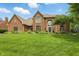 Charming two-story brick home with an arched entry, manicured lawn, and mature landscaping at 5419 Cayman Dr, Carmel, IN 46033