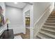 Bright foyer boasts staircase, wooden floors, and decorative wainscoting at 5419 Cayman Dr, Carmel, IN 46033