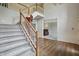 Grand staircase with carpeted steps, wood railing, white trim, and view into a carpeted living room at 5419 Cayman Dr, Carmel, IN 46033