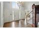 Bright foyer with hardwood floors, white trim, chandelier, and grand staircase with white walls at 5419 Cayman Dr, Carmel, IN 46033