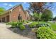 Charming brick home with lush landscaping, including garden and beautiful green lawn at 5419 Cayman Dr, Carmel, IN 46033