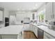 Bright kitchen featuring white cabinets, quartz countertops, stainless steel appliances, and a large window at 5419 Cayman Dr, Carmel, IN 46033