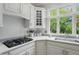 Close up of kitchen with gas cooktop, white cabinets, quartz countertops, and natural lighting at 5419 Cayman Dr, Carmel, IN 46033