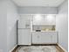 Simple kitchenette features white cabinetry, wooden floors, and neutral paint at 5419 Cayman Dr, Carmel, IN 46033