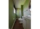 Green bathroom with a shower, toilet, vanity, and window at 5515 Lunsford Dr, Indianapolis, IN 46237