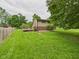 Backyard featuring lush green grass, home, and a wood deck perfect for outdoor living at 5542 N Olivia Dr, Alexandria, IN 46001