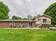 Large backyard featuring lush green grass, brick home, and a wood deck perfect for outdoor living at 5542 N Olivia Dr, Alexandria, IN 46001
