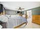 This primary bedroom has a four-poster bed, gray accent wall, ceiling fan, and a glimpse of the next room at 5542 N Olivia Dr, Alexandria, IN 46001
