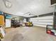 Spacious garage with overhead door, yard equipment, workbench, and storage at 5542 N Olivia Dr, Alexandria, IN 46001