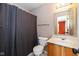 Bathroom with grey shower curtain, wood vanity, and toilet at 560 Tracy Ln, Brownsburg, IN 46112