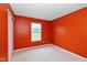 Bedroom featuring neutral carpet, window, and bright orange walls at 560 Tracy Ln, Brownsburg, IN 46112