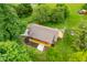 Aerial shot showcases a charming home with a large deck nestled amidst trees on a verdant property at 5730 S 50 W, Trafalgar, IN 46181