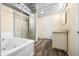 Bright bathroom features vanity, shower, soaking tub, metal ceiling, and wood-look floors at 5730 S 50 W, Trafalgar, IN 46181