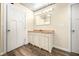 Bright bathroom features vanity, mirror, metal ceiling, and wood-look floors at 5730 S 50 W, Trafalgar, IN 46181