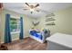 Bedroom with wooden floors, ceiling fan, large window, and space for displaying favorite toys at 5730 S 50 W, Trafalgar, IN 46181