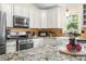 A bright kitchen featuring stainless steel appliances, granite countertops, white cabinets and modern fixtures at 5730 S 50 W, Trafalgar, IN 46181