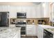 This kitchen features stainless steel appliances, granite countertops, white cabinets and tile backsplash at 5730 S 50 W, Trafalgar, IN 46181