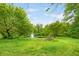 Scenic pond with fountain surrounded by lush green trees and foliage at 5730 S 50 W, Trafalgar, IN 46181