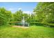 Scenic pond with fountain feature surrounded by lush greenery, offering a serene and picturesque view at 5730 S 50 W, Trafalgar, IN 46181