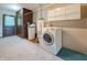 Well-equipped laundry area with a modern washer, water heater, storage, and carpeting at 5730 Teresa Dr, Alexandria, IN 46001