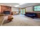 Finished basement with brick fireplace and hearth, recessed lighting, tile accent, plush carpet, and backyard access at 5730 Teresa Dr, Alexandria, IN 46001