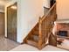 Wood staircase with carpet runners leads to an upper level and overlooks a cozy living area with a fireplace at 5730 Teresa Dr, Alexandria, IN 46001