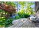 Outdoor deck with seating overlooking a lush, green backyard and beautiful red tree at 5873 N Victoria Dr, Indianapolis, IN 46228
