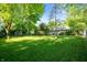 Expansive backyard with mature trees, a storage shed, and ample green space at 5873 N Victoria Dr, Indianapolis, IN 46228