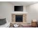 Close-up of the brick fireplace, complete with a mantel and decorative items at 5873 N Victoria Dr, Indianapolis, IN 46228