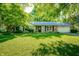 Charming single-story home with a well-maintained lawn and mature trees providing shade at 5873 N Victoria Dr, Indianapolis, IN 46228