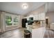 Well-lit kitchen with white cabinets, granite countertops, and laminate flooring at 5873 N Victoria Dr, Indianapolis, IN 46228