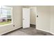 This carpeted bedroom offers a light filled window and a neutral color palette at 6010 Lakeside Manor Ave, Indianapolis, IN 46254