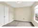 A light filled carpeted bedroom features double door closet, window and a neutral color palette at 6010 Lakeside Manor Ave, Indianapolis, IN 46254