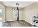 Well-lit dining area featuring new vinyl floors, a modern chandelier, and access to the backyard at 6010 Lakeside Manor Ave, Indianapolis, IN 46254