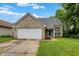 Charming single-story brick home with an attached two-car garage, green lawn, and a cloudy blue sky at 6010 Lakeside Manor Ave, Indianapolis, IN 46254