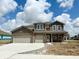 Charming two-story brick home featuring a three-car garage and inviting front entrance at 6032 Granby Dr, Whitestown, IN 46075